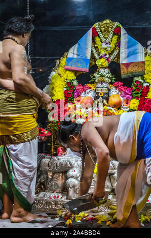 KUALA LAMPUR, MALAYSIA - DECEMBER 18, 2018: Hindu Priest preparing beautiful floral decoration to Hindu God Sri Ganesar, Kortumalai Court Hill temple. Stock Photo