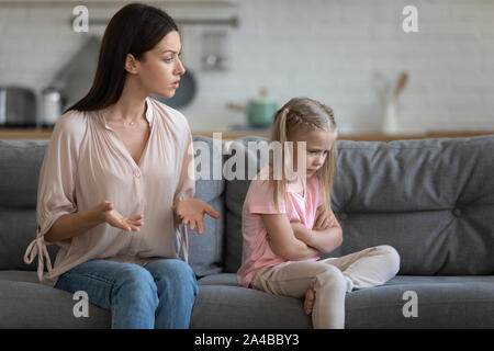 Stubborn upset little daughter ignoring strict mother, family conflict Stock Photo