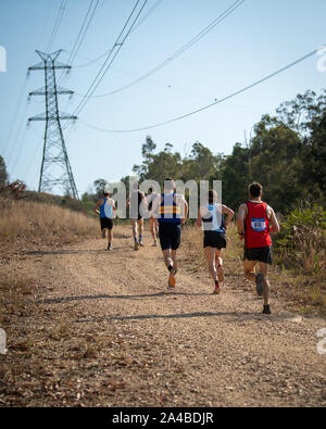 Camp Mountain, Brisbane, Queensland, Australia - Sept 15 2019: Competitors run up the bush trail under power lines in the Australian Mountain Running Stock Photo