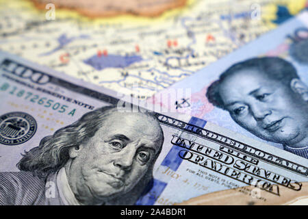 Chinese Yuan and US dollars on the map of China. Trade war between US and China, economic sanctions and international business Stock Photo