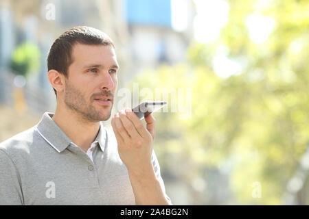 Man using voice recognition on mobile phone to record messages in the street Stock Photo