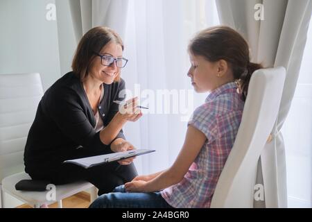 Teacher teaching and talking to a girl child, private individual lesson. Stock Photo