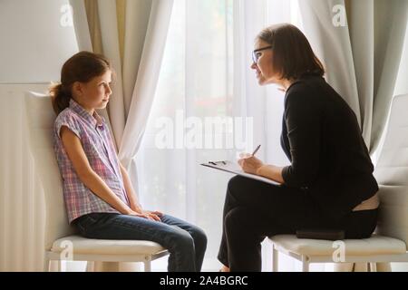 Teacher teaching and talking to a girl child, private individual lesson. Stock Photo