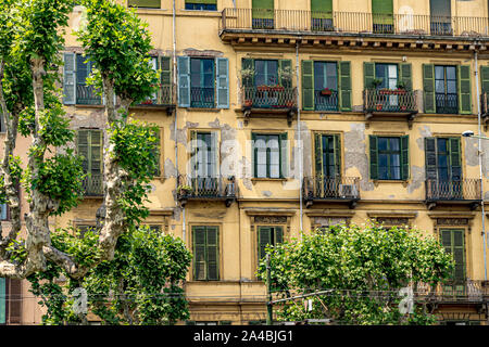 Yellow apartment building with green wooden shutters and wrought iron balconies along  Corso Cairoli ,Turin,Italy Stock Photo