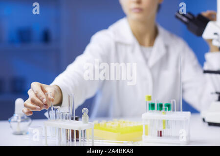 Close up of unrecognizable female scientist holding test tubes while doing research in medical laboratory, copy space Stock Photo