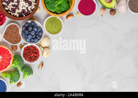 Healthy vegan or vegetarian food on whitemarble table. Vegetables, fruits, nuts and superfood. flat lay. top view with copy space Stock Photo