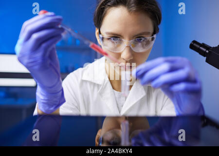 Portrait of focused female scientist working with blood samples in medical laboratory, copy space Stock Photo