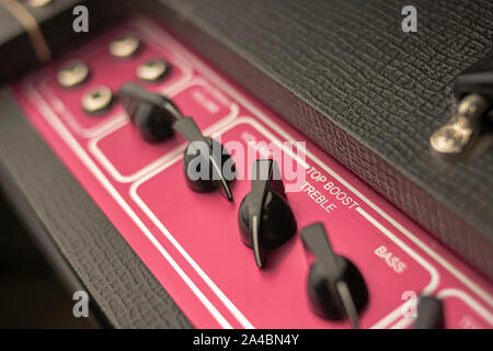 Close-up of the potentiometers of a classic rock and roll music amplifier, with regulators for volume, bass and treble, of the top boost system. Stock Photo