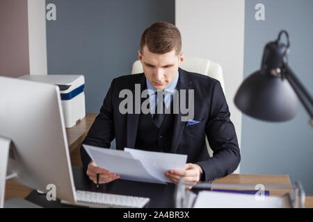 Businessman reading contract in office Stock Photo