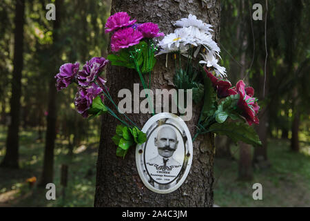 Photograph of one of the victims of Bolshevik political repressions installed by his relatives at the Levashovo Memorial Cemetery in the forest next to Levashovo railway station near Saint Petersburg, Russia. The forest became the mass burial place of the people executed during the Great Purge by the Soviet secret police NKVD, later known as the KGB. There were at least 19,000 victims of political repressions buried here from 1937 to 1954. According to other sources, about 45,000 people could be buried at at the Levashovo Memorial Cemetery in unmarked graves. Stock Photo