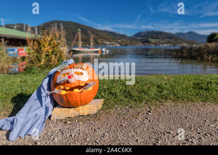 A doctor helloween pumpkin outside in front of an idyllic lake. Stock Photo