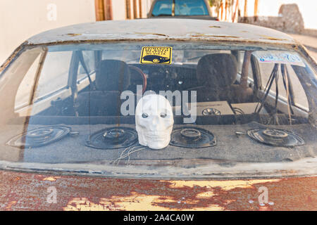 An old car with a skull decoration parked in the ghost town of Mineral de Pozos, Guanajuato, Mexico. The town, once a major silver mining center was abandoned and left to ruin but has slowly comeback to life as a bohemian arts community. Stock Photo