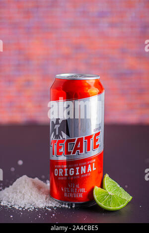 Tecate beer can with salt and limes on the side on a vertical view Stock Photo