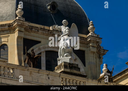 Statue of archangel Michael fighting Satan on the facade of Cathedral of Our Lady of La Almudena by Royal Palace in Madrid, Spain consecrated in 1993 Stock Photo