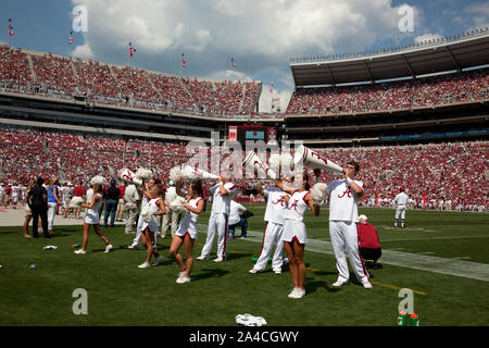 The cheerleaders are amazing to watch. The boys throw the girls into the air as they cheer on their winning team. University of Alabama football game, Tuscaloosa, Alabama Stock Photo