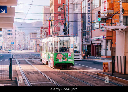 DEC 2, 2018 Hakodate, JAPAN - Hakodate city tram vintage streetcar approaching station near JR train station. The Tram well-established network throug Stock Photo