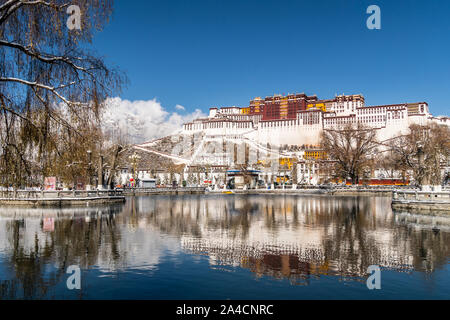 Stunning view and reflection of the famous Potala Palace in the heart of Lhasa in Tibet province in China on a sunny winter day with snow covered mout Stock Photo