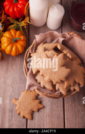Homemade cookies in the basket, autumn leaves, pumpkins, candles on the wooden table. Autumn harvest. Autumn concept. Top view. Stock Photo