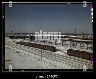 The freight house at a Chicago and Northwestern Railroad yard. In the foreground are old cars used as living quarters for some yard workers and itinerant help Stock Photo