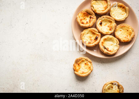 Pastel de Nata Portugese egg custard pies on white background, top view, copy space. Stock Photo