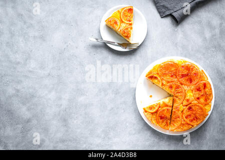 Orange Upside Down Cake on grey background, copy space. Homemade cake with bloody oranges, citrus fruits. Stock Photo