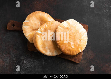 Indian Naan Flat Bread on dark rustic background, top view, copy space. Homemade Flatbread (naan, pita) cooked in tandoor oven. Stock Photo