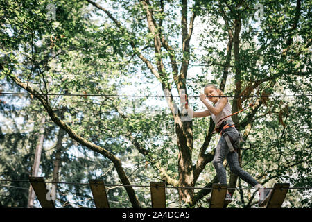 Girl playing in a tree top adventure park Stock Photo