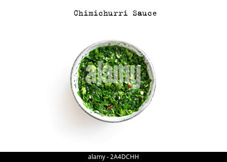 Raw homemade chopped green Chimichurri or Chimmichurri sauce made of parsley, garlic, oregano, hot pepper, olive oil, vinegar, isolated on white, top Stock Photo