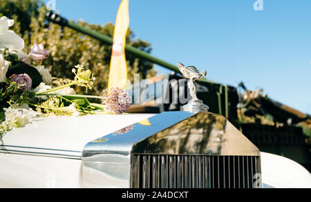 Paris, France - Sep 21, 2019: Luxury Rolls-Royce British luxury car logotype with the Spirit of Ecstasy bonnet ornament and flowers on the hood Stock Photo