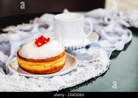 White flower doughnut with glass and lace on the table Stock Photo