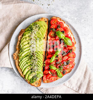 Avocado toast and a hummus tomato toast on a plate