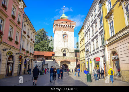 Tourists and locals spending their time at St. Florian's Gate, the Polish gothic city defense walls with medieval towers in Krakow, Poland Stock Photo