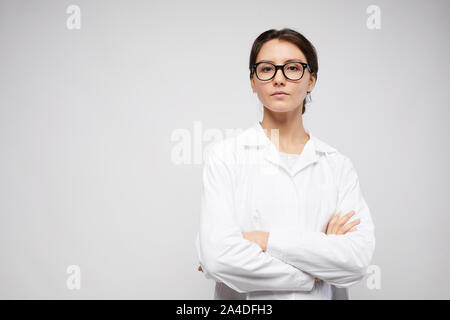 Waist up portrait of confident female scientist standing with arms crossed while posing against white background, copy space Stock Photo