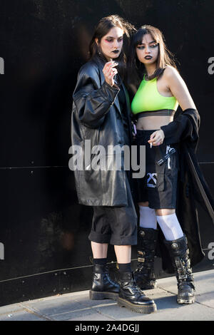 LONDON, ENGLAND - September 15, 2019 Stylish attendees gathering outside 180 Strand for London Fashion Week. Two girls dressed in black and green goth Stock Photo