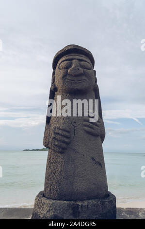 Jeju Island, South Korea, september 05, 2019: View of one of the Dol Hareubang on Geumneung  beach with sea behind it Stock Photo