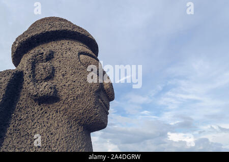 Jeju Island, South Korea, september 05, 2019: profile view of Dol Hareubang on Geumneung beach with beautiful cloudscape on background Stock Photo