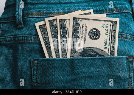 A hundred American bills in cash in the back pocket of his jeans Stock Photo