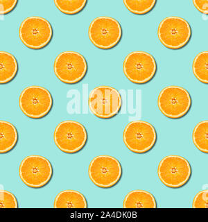 Seamless pattern of orange sliced on neo mint green color background. Minimal, flat lay, food texture. Stock Photo