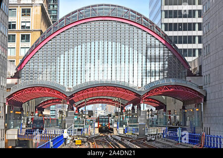 High curved glass roof over Docklands Light Railway DLR Canary Wharf train station platform trains at interchange platforms East London England UK