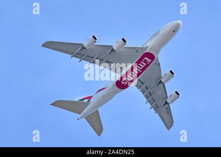 Close up underside view of Emirates airline business Airbus A380 800  jet airplane aeroplane in flight plane low over London on Heathrow approach UK