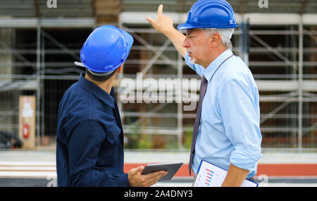 Two architect developers reviewing building plans at construction site Stock Photo