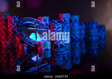 Casino theme.  Gambling games. Roulette, dice and poker chips on a colorful bokeh background. Stock Photo