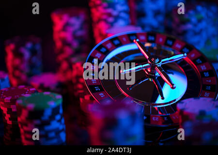 Casino theme.  Gambling games. Roulette, dice and poker chips on a colorful bokeh background. Stock Photo