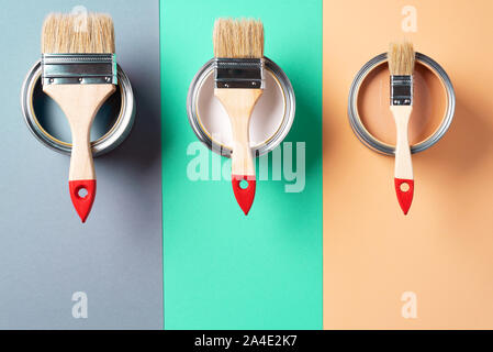 Metal paint cans and paint brushes on multicolor background. Top view. Copy space. Trendy green color concept. Stock Photo