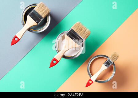 Metal paint cans and paint brushes on multicolor background. Top view. Copy space. Trendy green color concept. Stock Photo