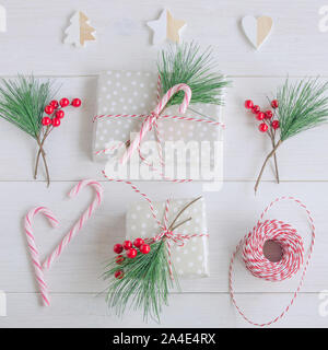 Accessories for packaging Christmas gift ,fir tree branch with red, wrapping  paper, roll of Red and white thread , christmas candy and different wrap  presents. Stock Photo