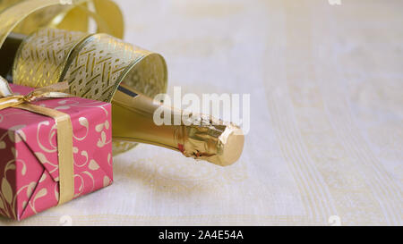 The bottle of champagne with gold glossy ribbon and red gift. Happy New ...