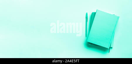 Top view of open notebooks on trendy green and turquoise color. Copy space. Woman business, study, back to school concept. Time managenet, to do list. Stock Photo