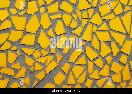 Mosaic of single yellow tile pieces on concrete Stock Photo