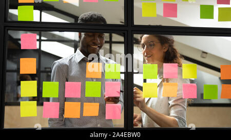 Multiracial colleagues developing business ideas use post-it notes Stock Photo